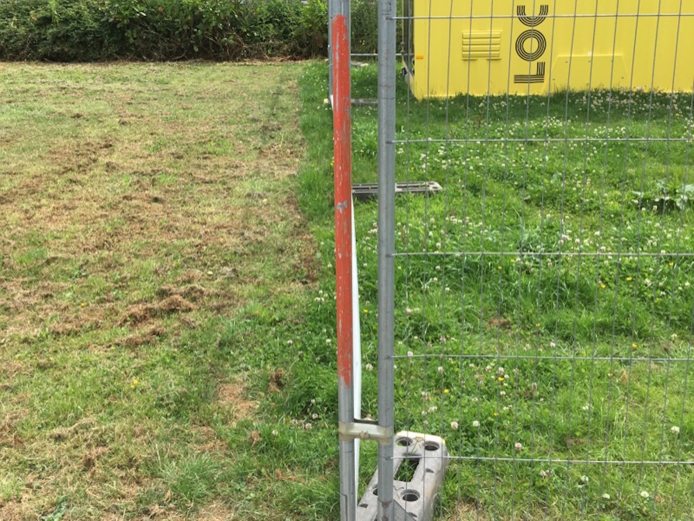 Lawn seperated by fence, one side recently cut 