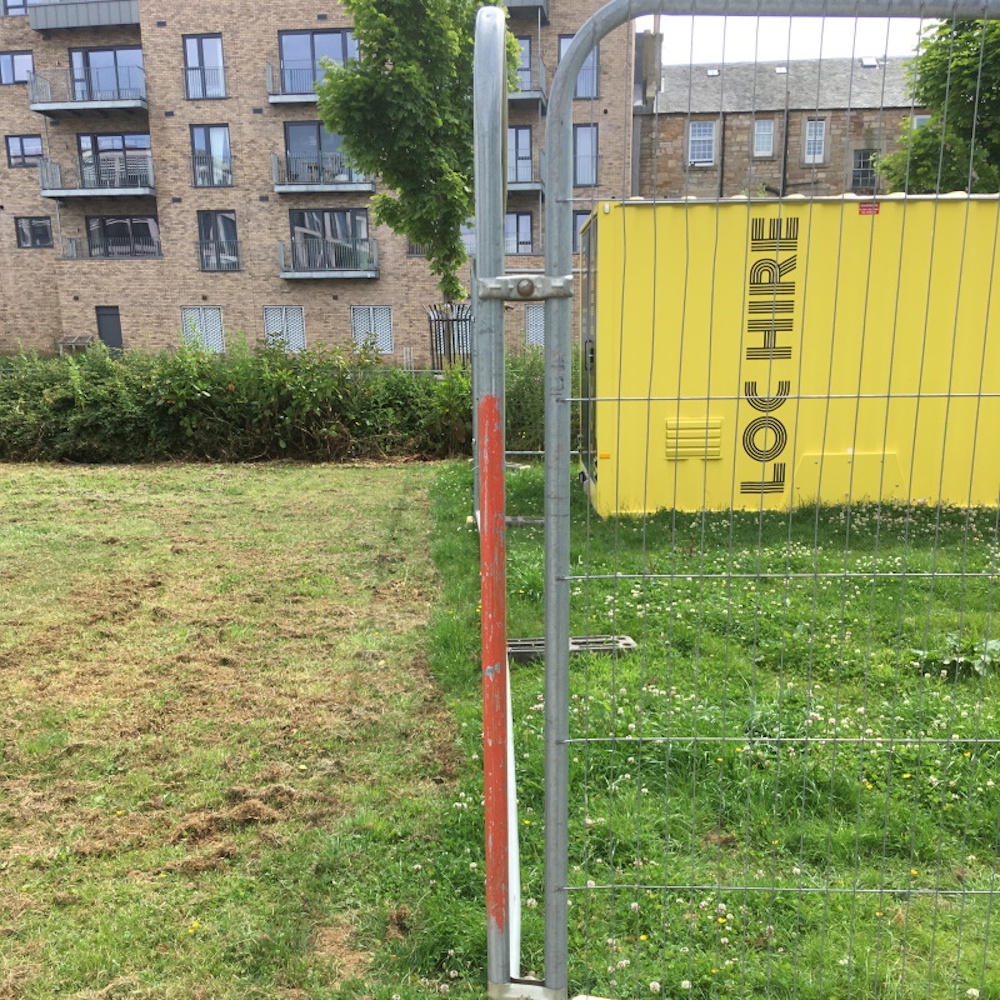 A lawn bisected some Herris fencing